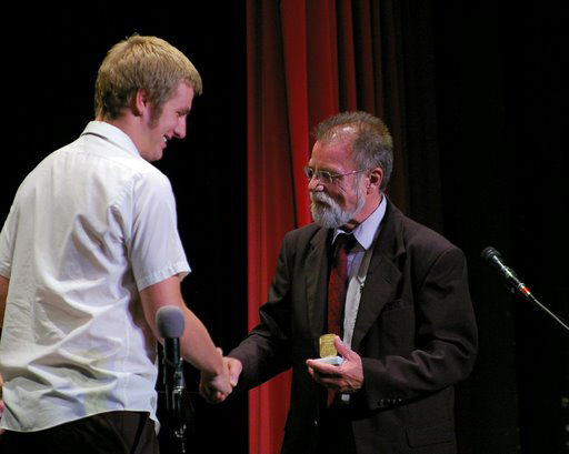 Bassist Ryan Niebuhr (left) accepts the Louis Armstrong Award from director Jack Plovanich.