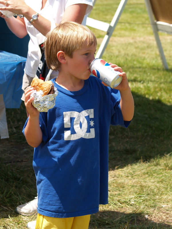 Kevin Sandman, 6, munches on a burger and soda after the parade