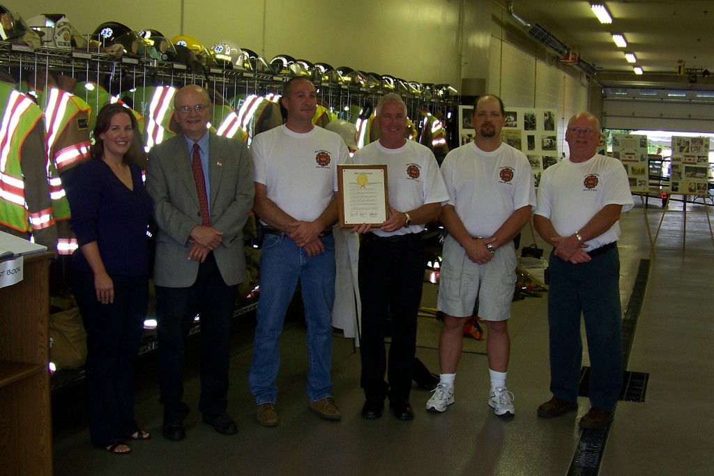 State Rep. Samantha Kerkman and state Sen. Bob Wirch (left) present Chief Stan Clause and other leaders of the Twin Lakes Fire Department with a plaque from the state legislature honoring the department on the occasion of its 80th anniversary.