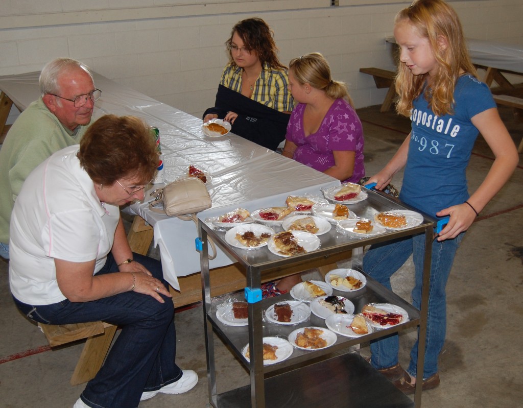 Carrie Weis (right) was one of several 4-H kids wheeling around dessert carts. Here, (clockwise from left) Barb Kruk, Don Kruk Sr., Catie Suess and Izzy Suess check out the options.