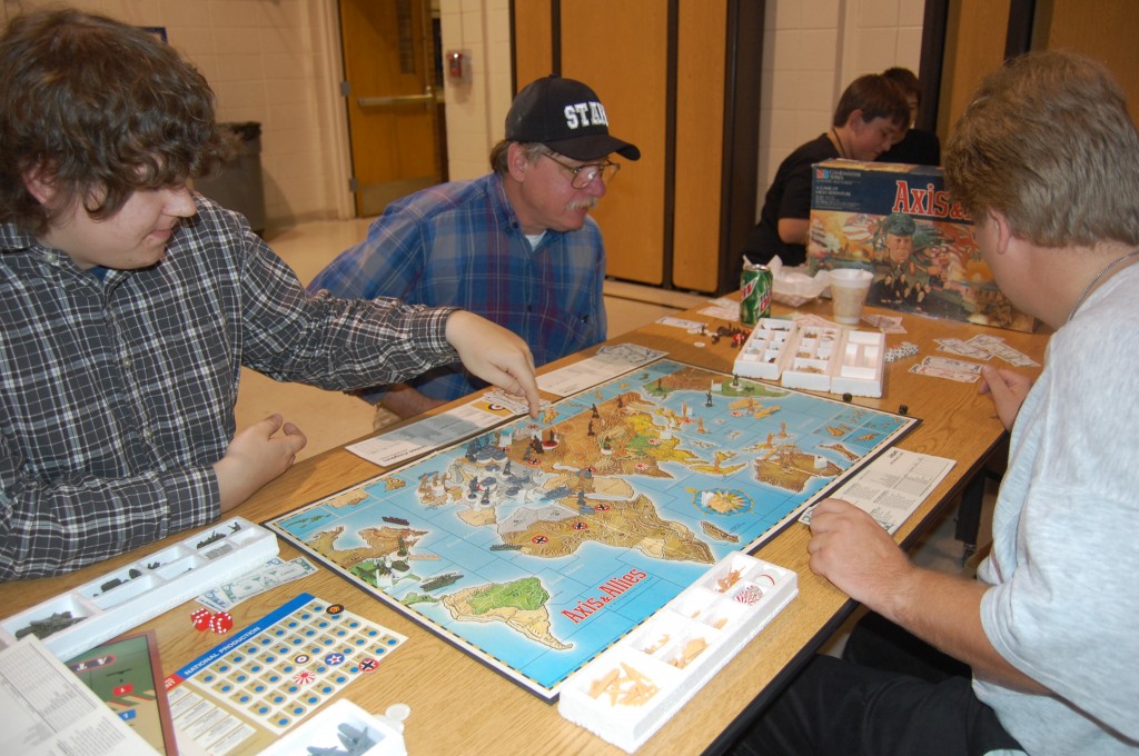 Matthew Taylor (left), John Ours and Matt Littlefiedl play a game of Axis and Allies, a board game. The three were playing the game at the Westosha Area Gaming Society booth.