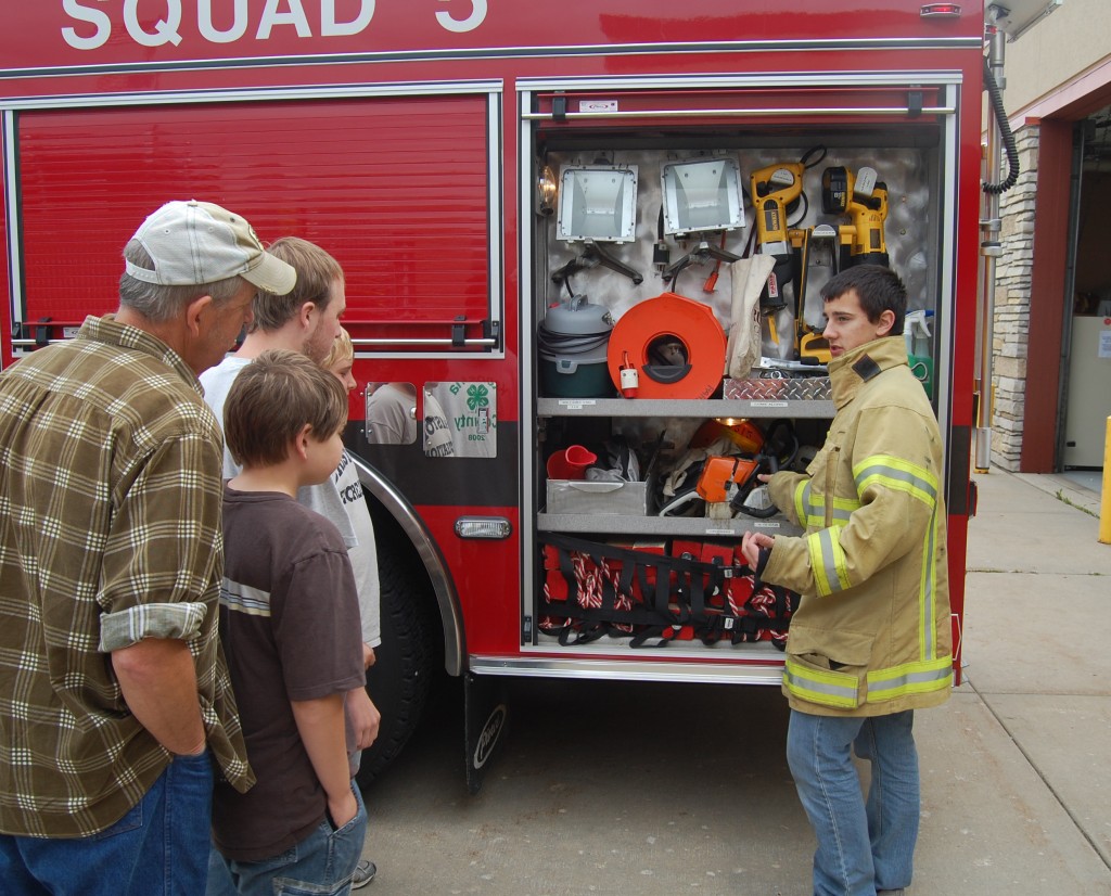 Paris firefighter Mike Jessen explains the equipment on one of the department's rigs at the department's open house Sunday. 