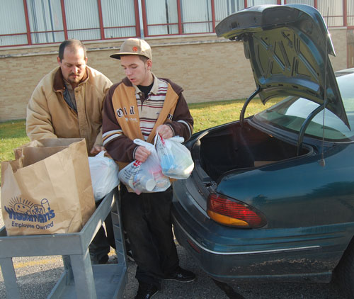 Aaron and Matthew Mountain unload a trunk of donations.