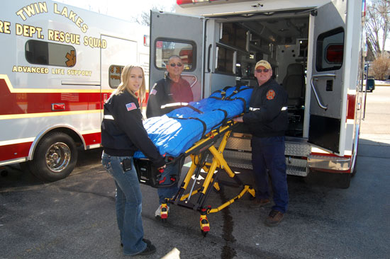 From left, EMT-I Ashley Amborn, Capt. Buster Amore and EMS Division Chief Darrel Stoen prepare to load one of the new Stryker Power Cots into an ambulance.