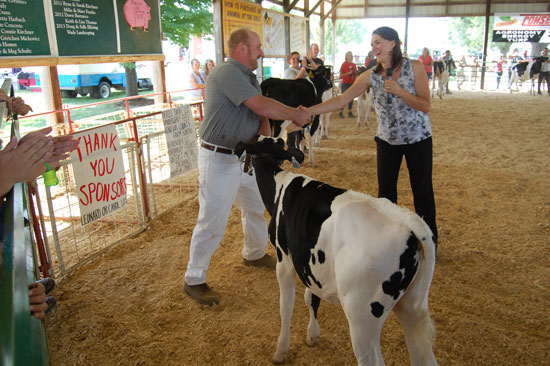 Tim Weiss is presented with the champion of the alumni showmanship class trophy. The calf Weis was showing slipped out of its halter, and he, with a little help, chased it down and got the halter back on. That, the judge said, was showmanship. Afterwards, Weis said with a smile that he thought it might have been more entertainment than showmanship.