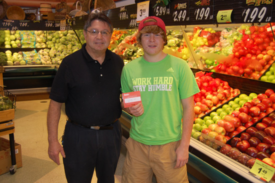 Lakeside Sentry produce manager Dave Matalas (left) presents Kyle Samples with the $100  Sentry gift card he won in westofthei.com's fair booth guessing contest.