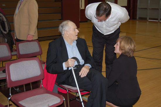 Leah Holloway (right) chats with her grandfather, veteran and Central High School founder Lloyd Holloway (seated) and her father and current School Board member John Holloway (standing) after the Assembly.