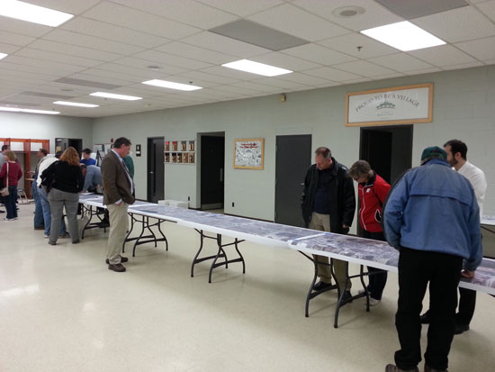 Residents examine a long aerial photo of the Hwy. 45 project with an overlay of the project's improvements.