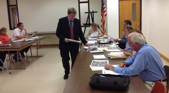 County Executive Jim Kreuser distributes information on a proposed Park and Ride lot at I-94 and Highway 142 to the Paris Town Board at a meeting Tuesday in Paris.