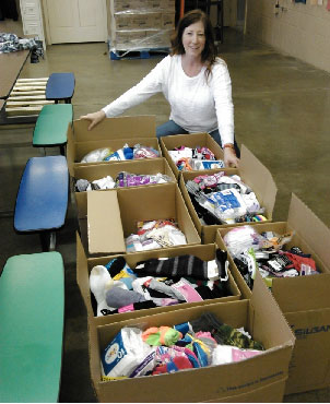 The Sharing Center's Sharon Pomaville with some of the socks collected by Western Kenosha County students. /Contributed photo