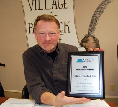 Paddock Lake President Terry Burns and the award from Society's Assets.